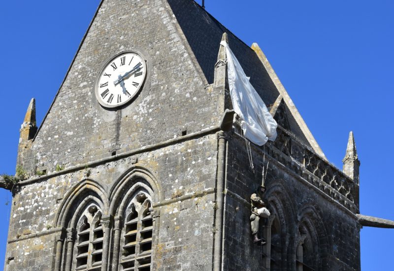 D-day Saint Mere Eglise, il parà sul tetto della chiesa e la vetrata artistica che ricorda l'atterraggio dei parà Usa
